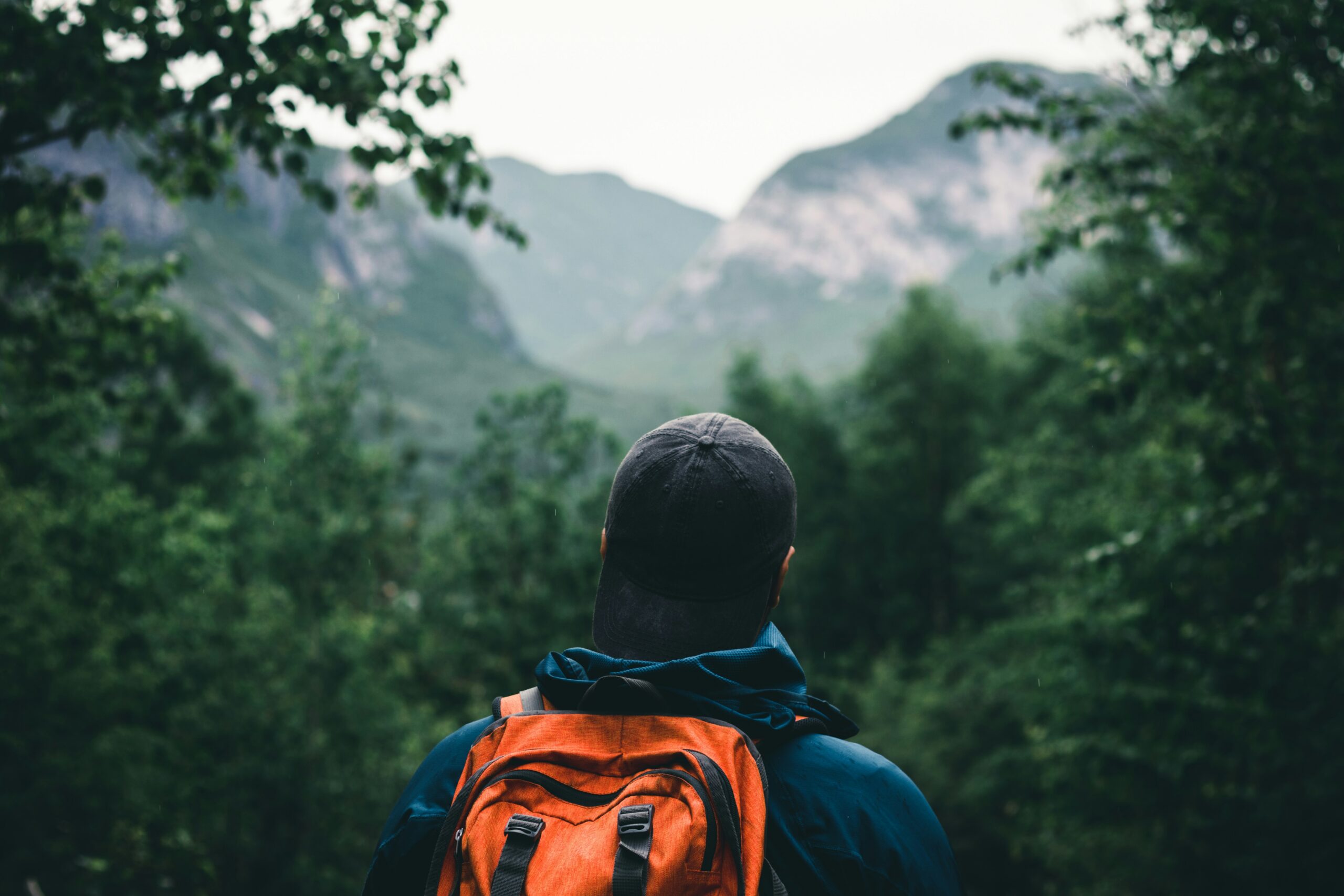 A traveler with a backpack looking out at a mountain range, representing freedom and a 1 year of cash flow runway.