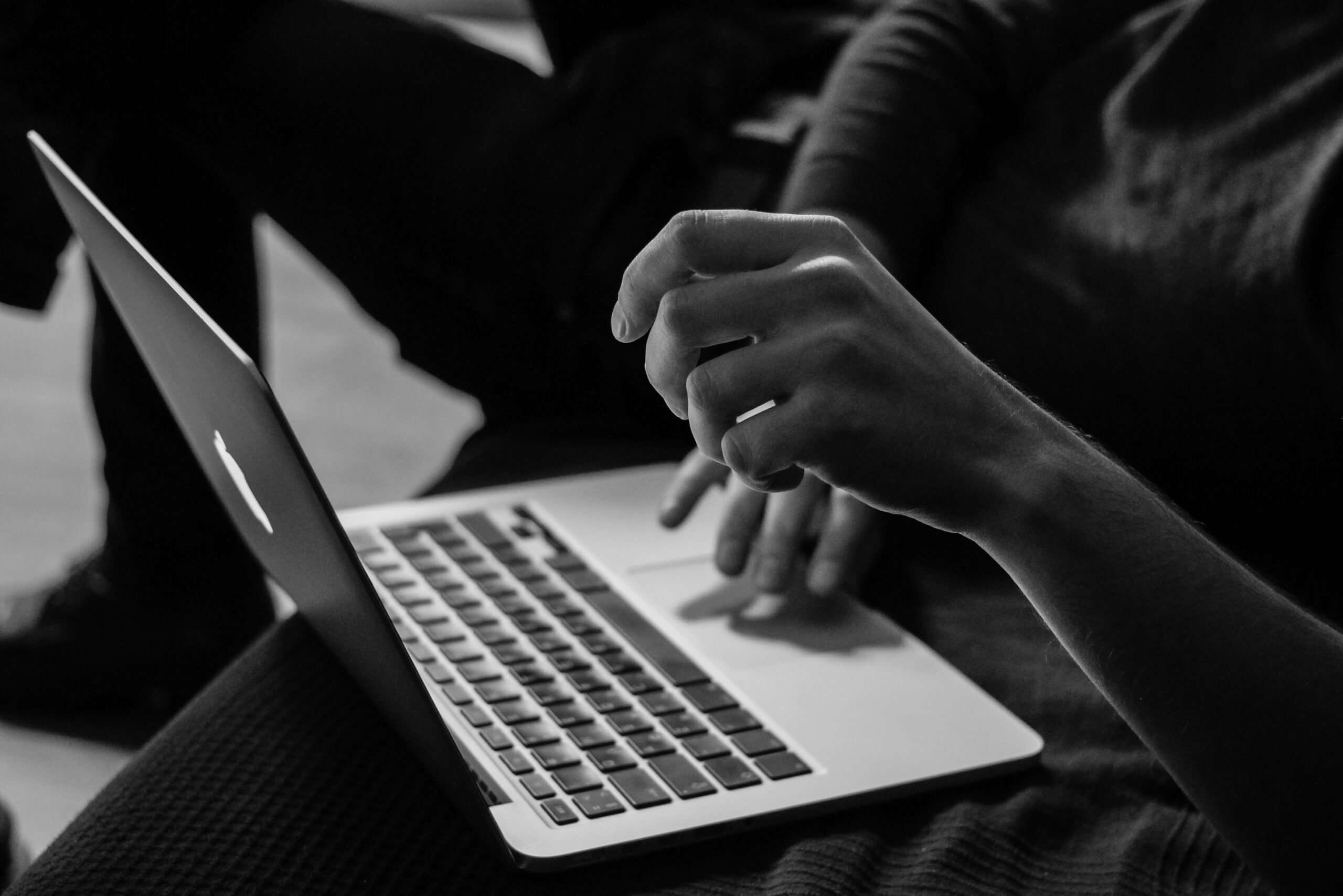 Person typing on a laptop computer using a side hustle income tracker spreadsheet