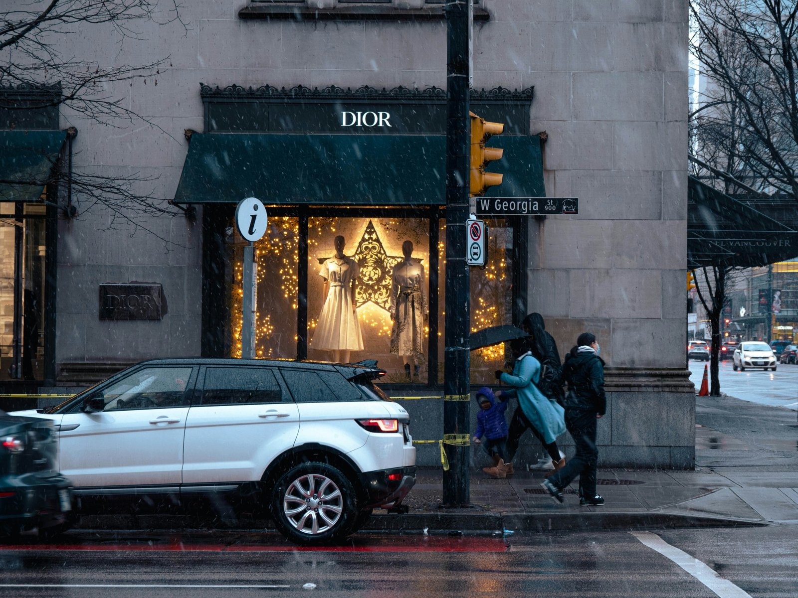 Dior storefront on W Georgia St in Vancouver during a light snowfall with pedestrians walking by