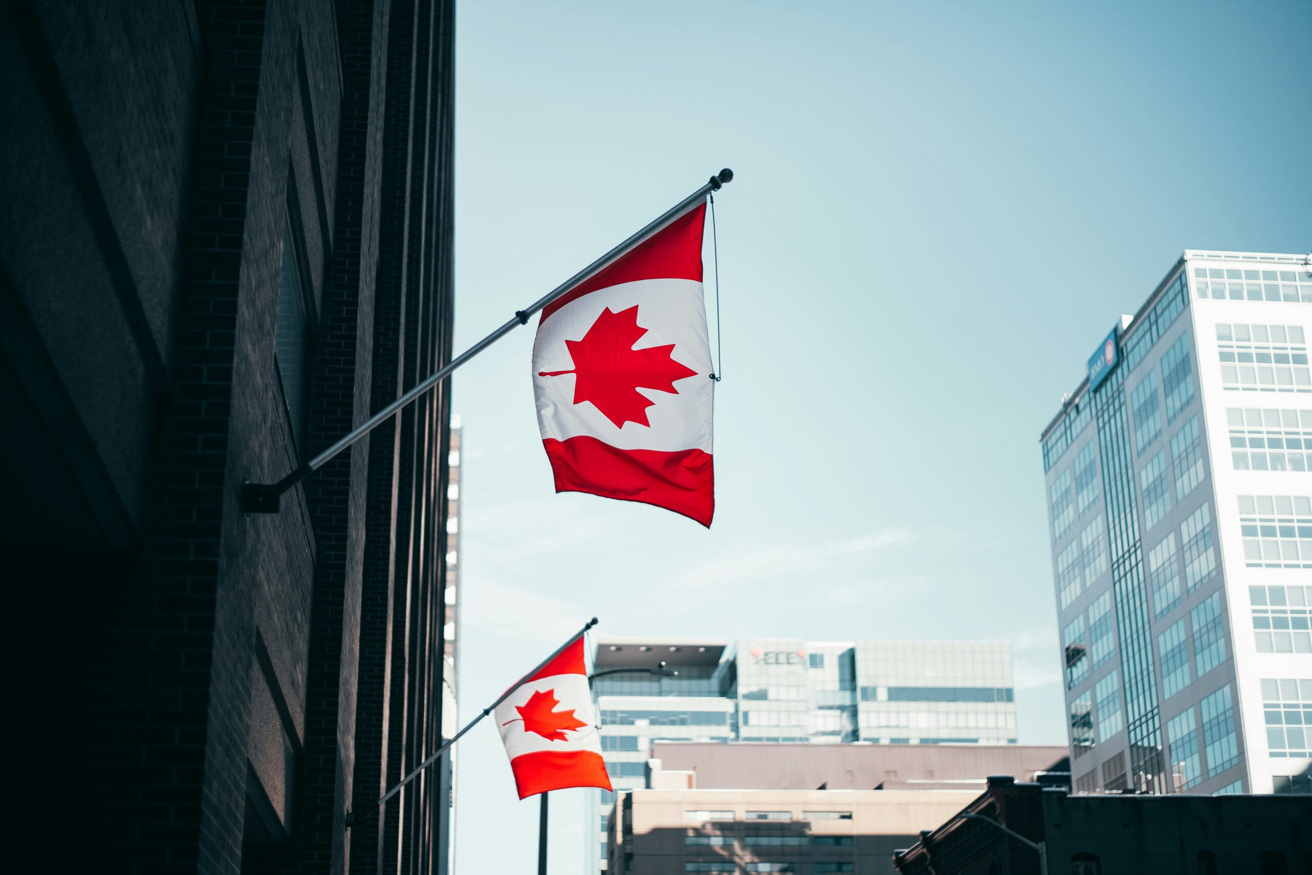 Canadian flags against a city skyline, illustrating how much emergency fund Canada workers actually need