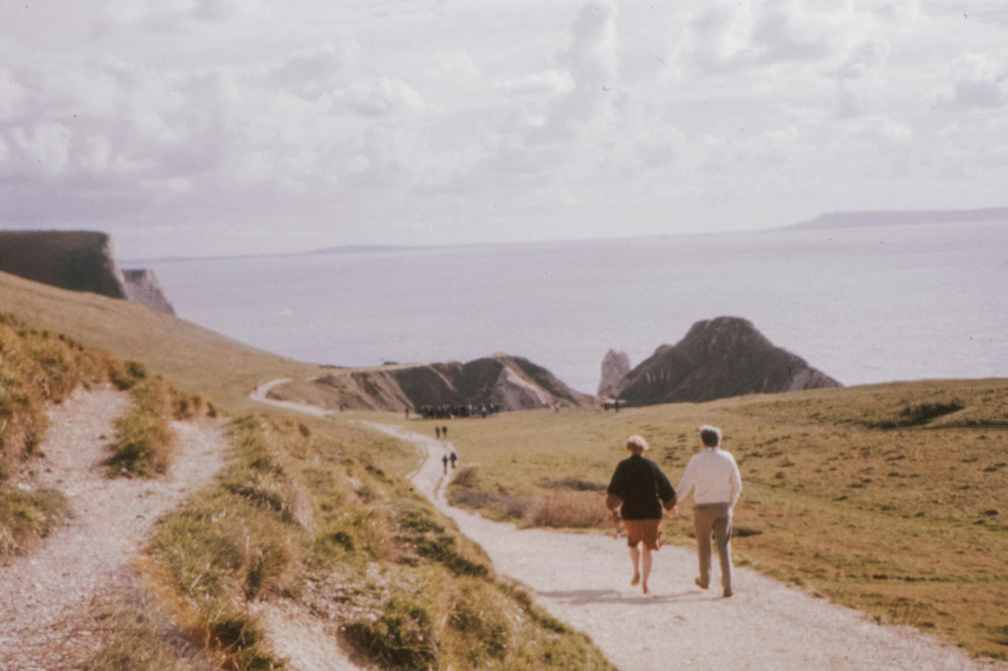 Three people walking together on a white sand beach, representing the freedom that Financial Independence, Retire Early is meant to buy back