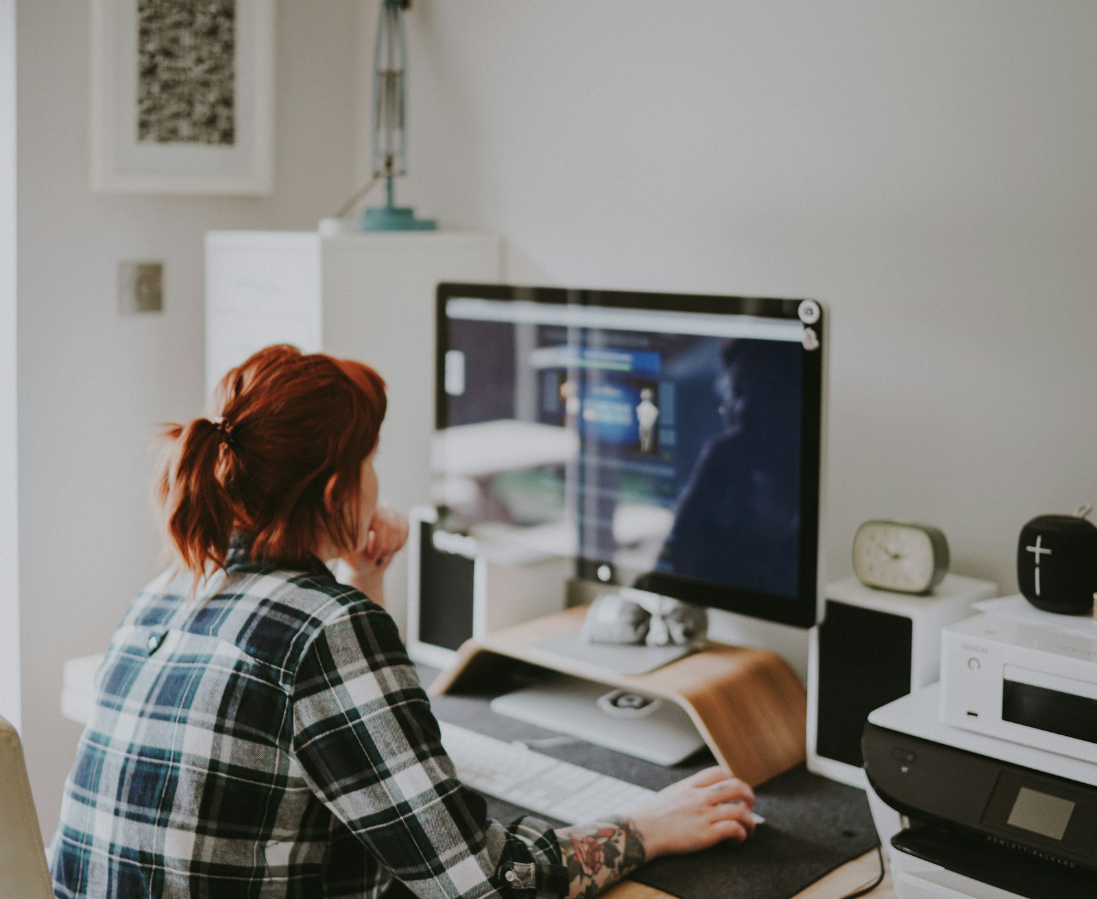 A woman working at a computer desk, representing how to make money with ChatGPT by speeding up freelance writing and research work she already knows how to do